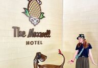 Girl in front of dog-friendly The Maxwell Hotel with a bronze statue of a dog