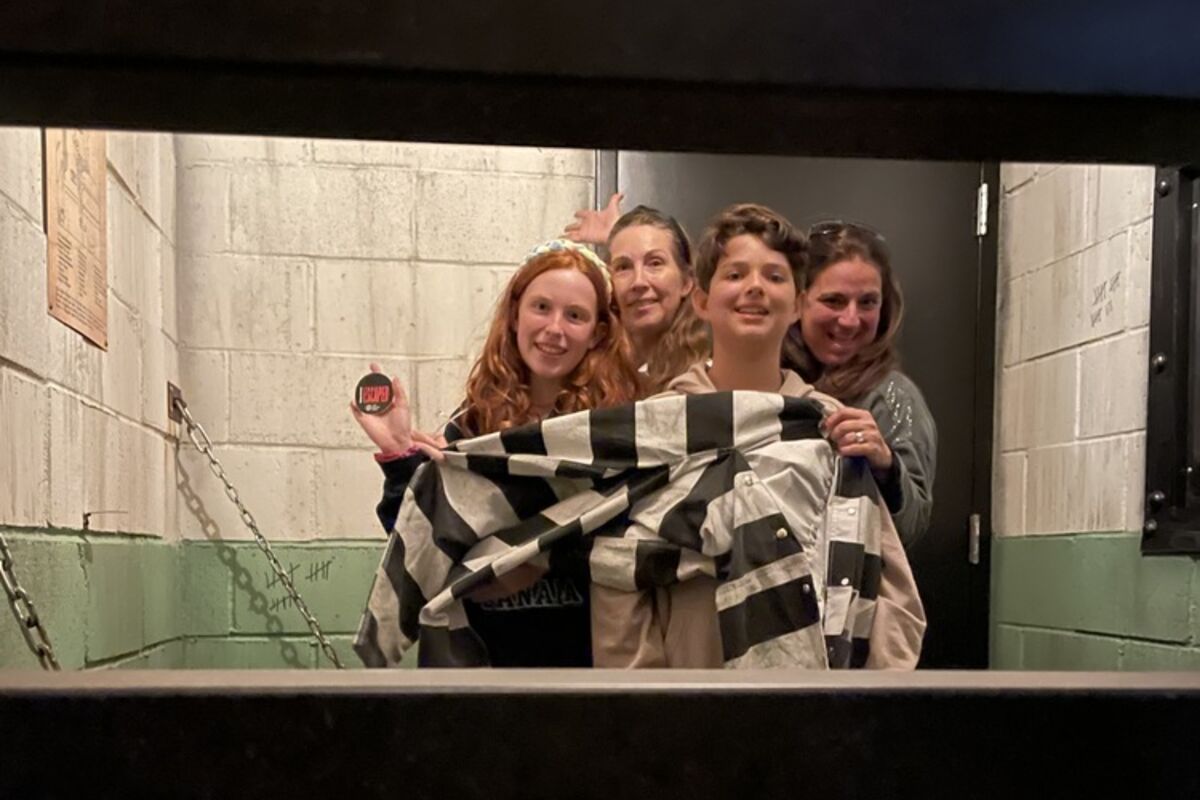 four people in a jail cell in an escape game.