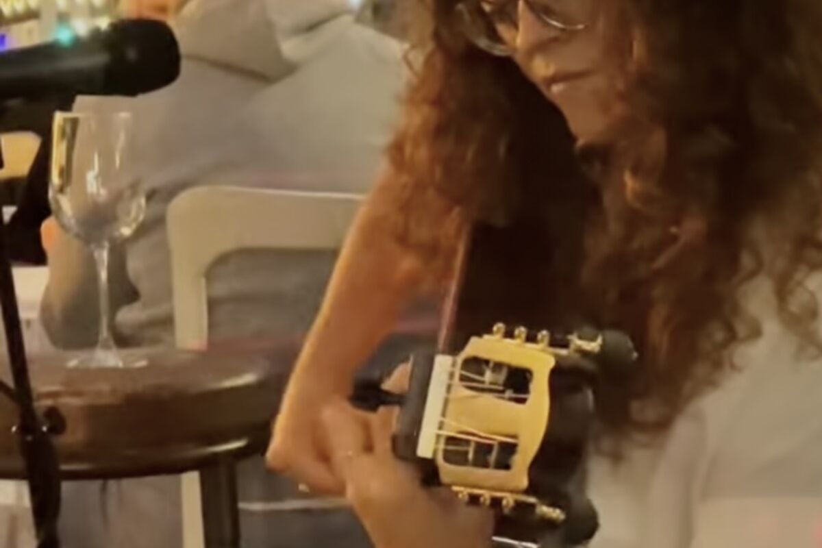 Woman playing Spanish guitar music at Manchego Tapas Restaurant